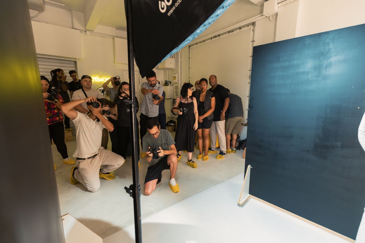 Photographers participating in a hands-on group photography workshop in a studio setting.