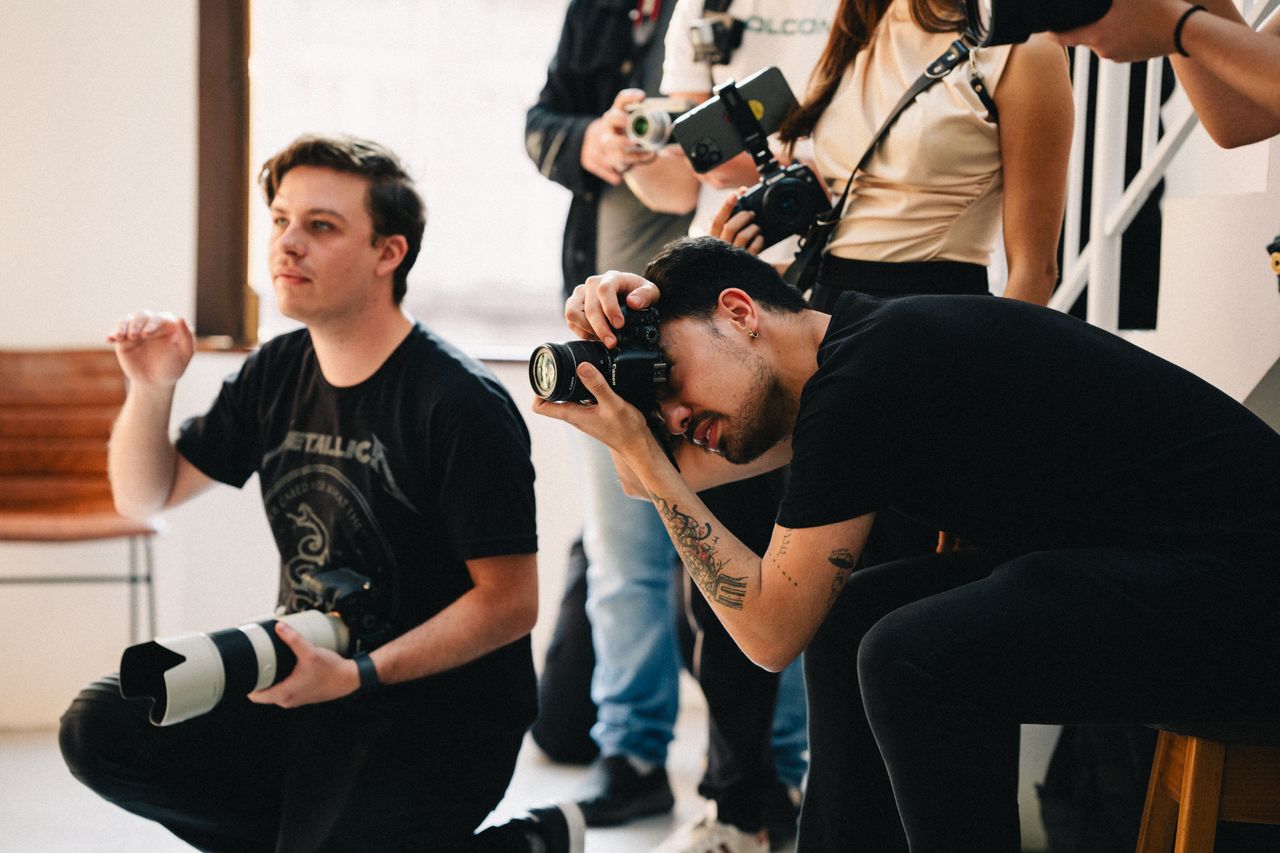 Photographers collaborating during an indoor event, capturing professional images.